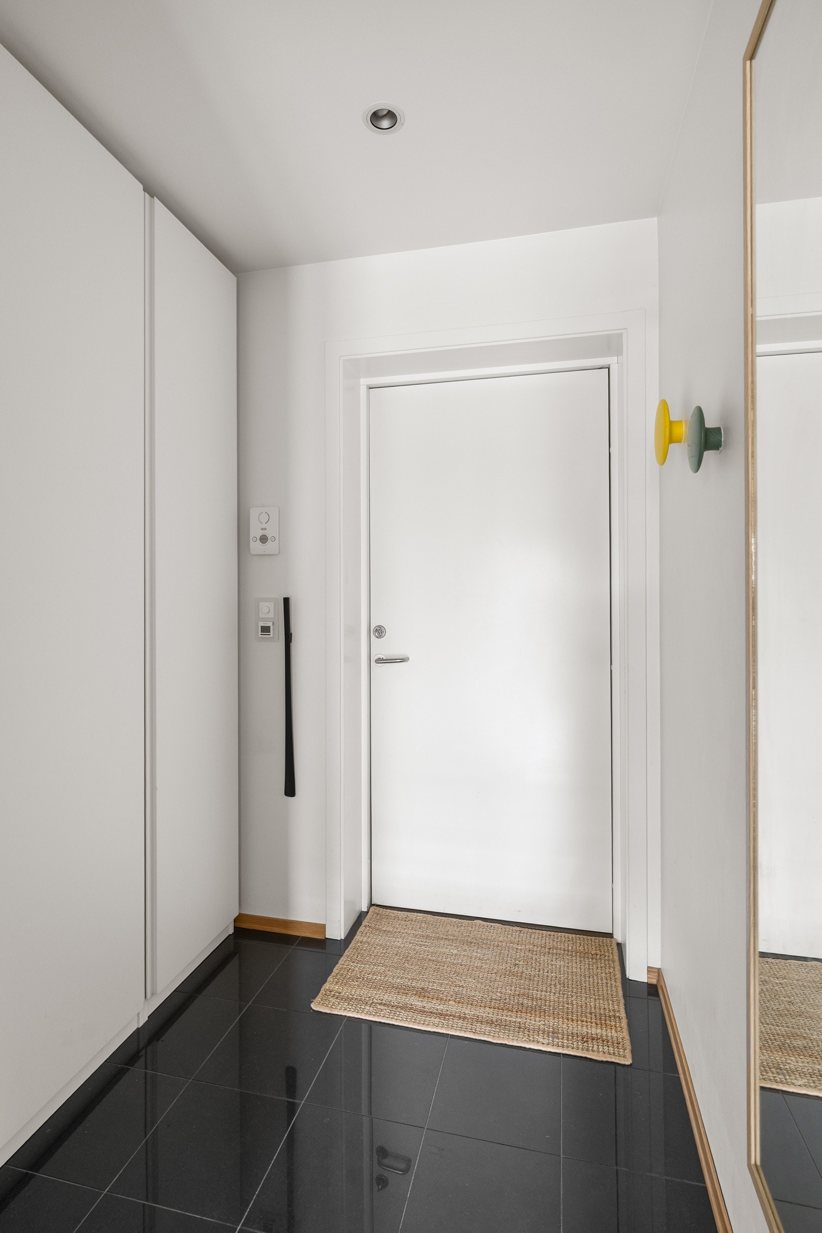 Innbydende flislagt entré med varmekabler i gulv og skyvedørsgarderobe. Galleribilde