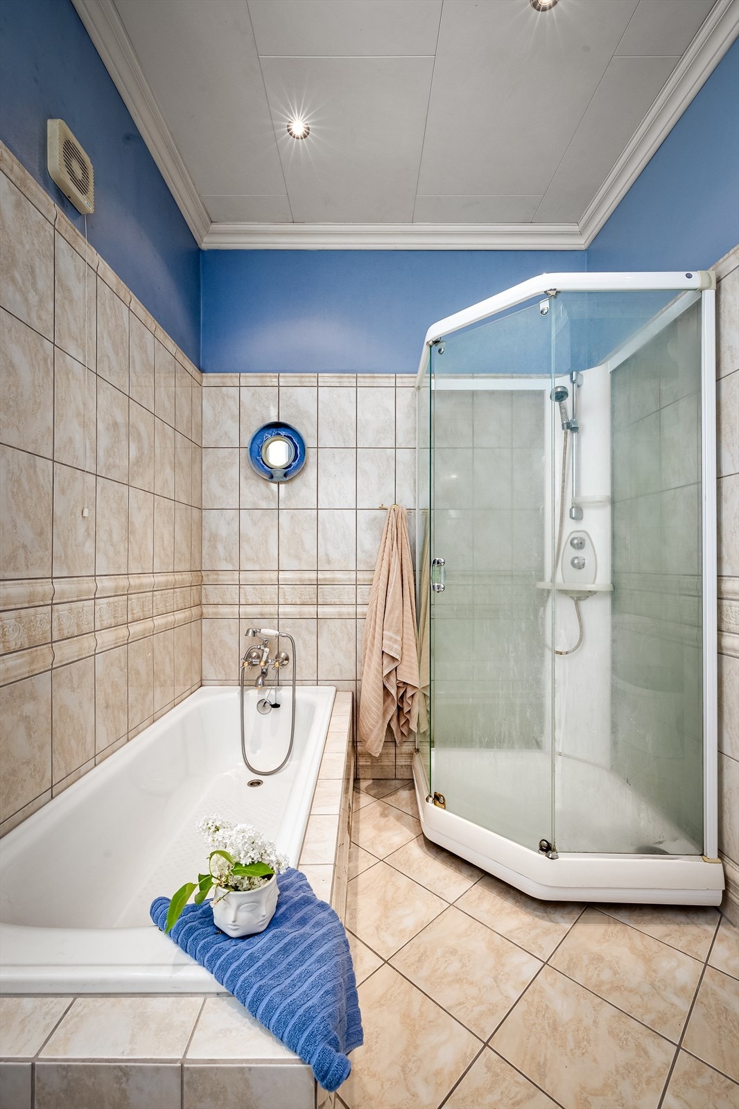 Rommet er innredet med baderomsinnredning, innmurt badekar, dusjkabinett og gulvstående toalett Galleribilde