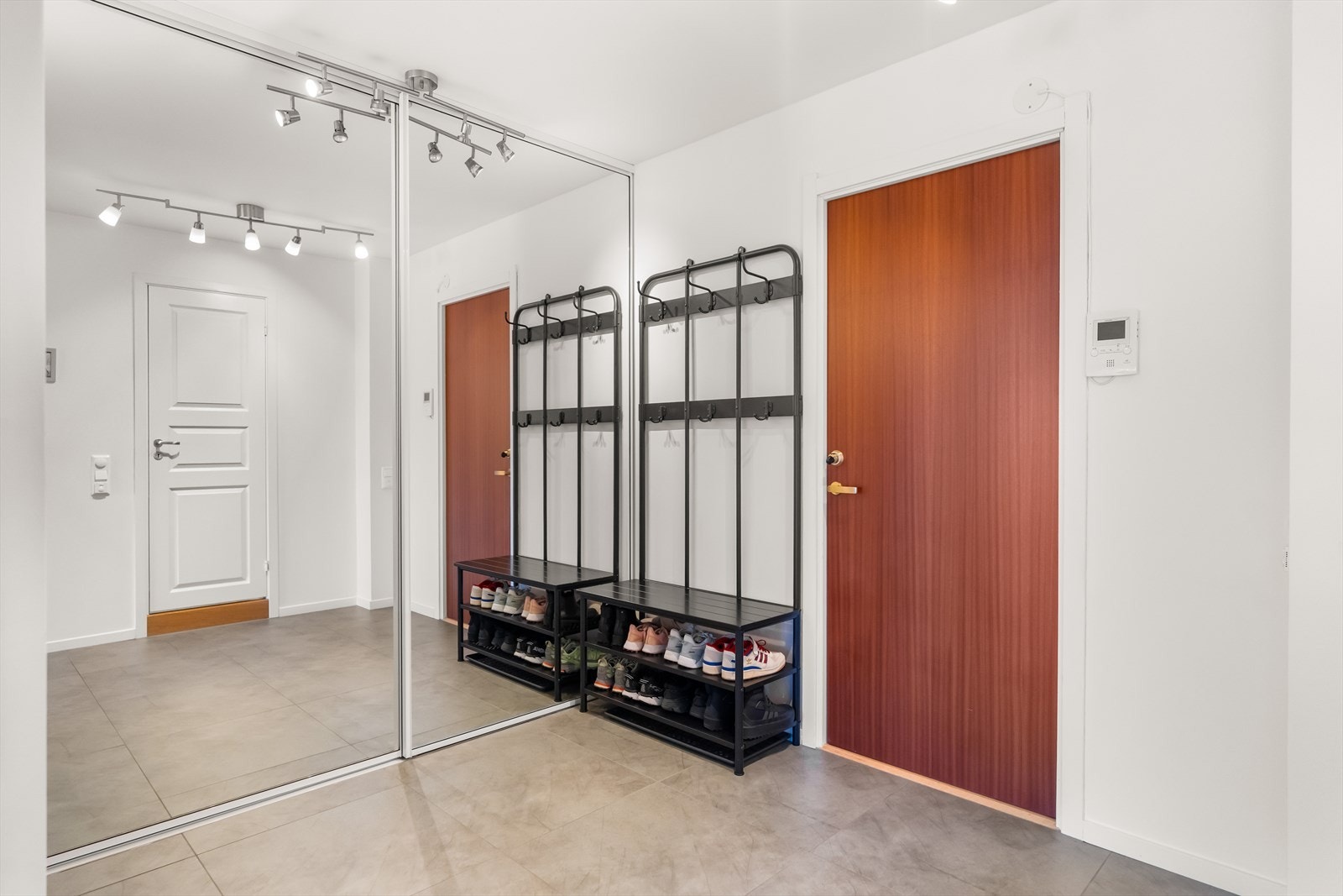 Lys og romslig entré med praktisk skyvedørsgarderobe med speil - et godt førsteinntrykk av boligen! Galleribilde