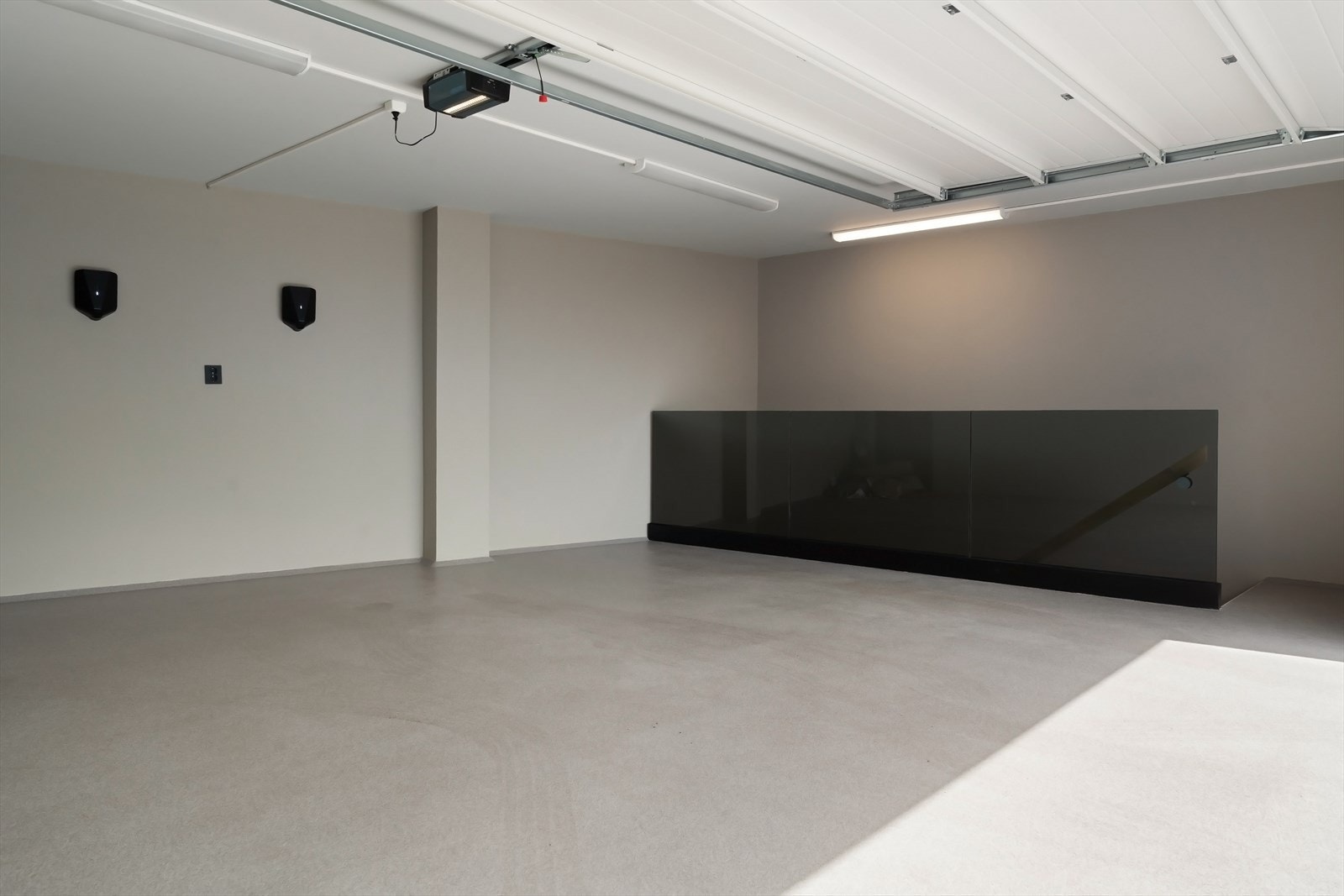 Romslig dobbelgarasje på 71 kvm over 2 plan. Hörmann leddport og 2 stykk elbilladere. Vannbåren gulvvarme i begge etasjer. Galleribilde