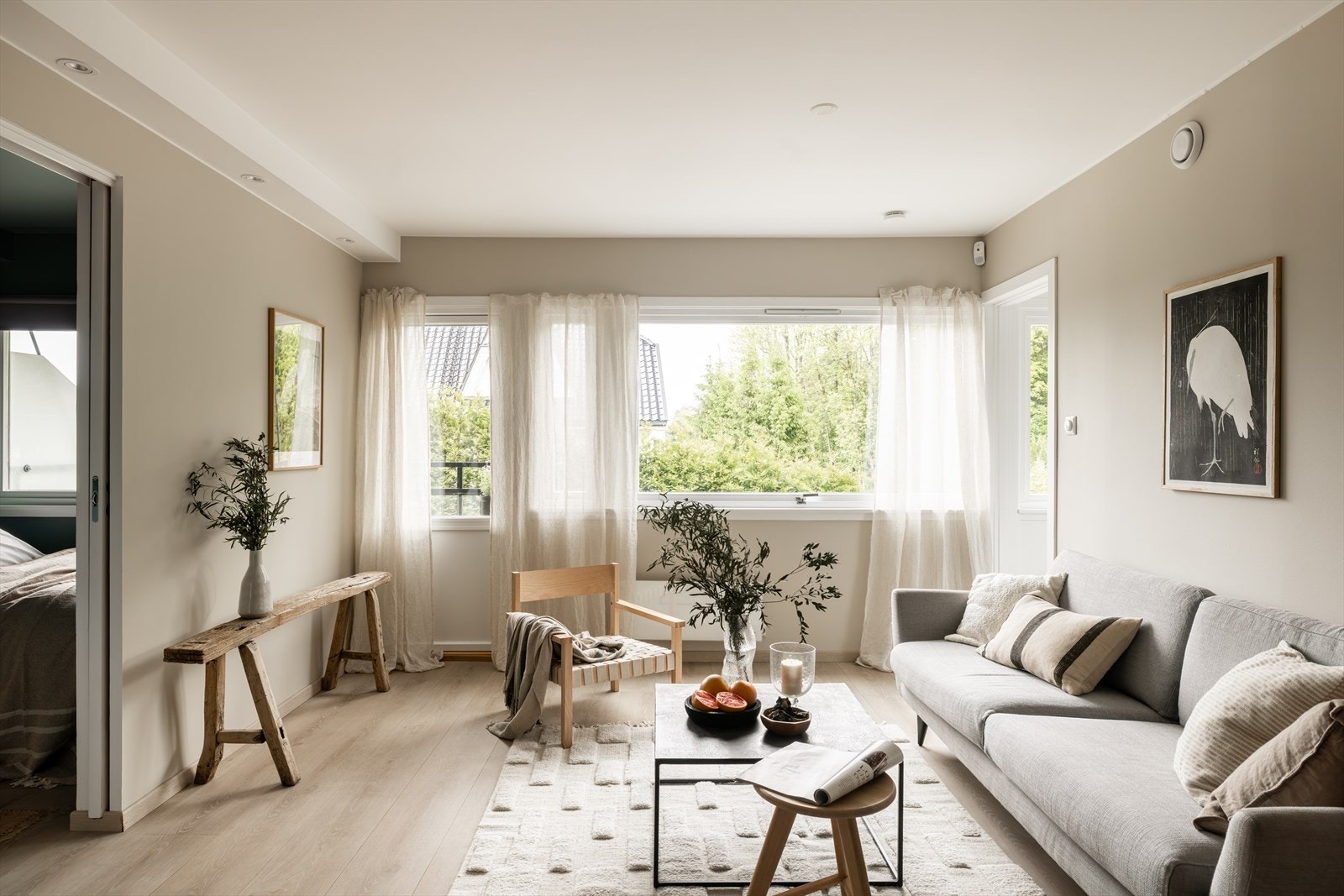 Lys og innbydende stue med store vindusflater som gir rikelig med naturlig lys og utsyn mot grønne omgivelser. Galleribilde