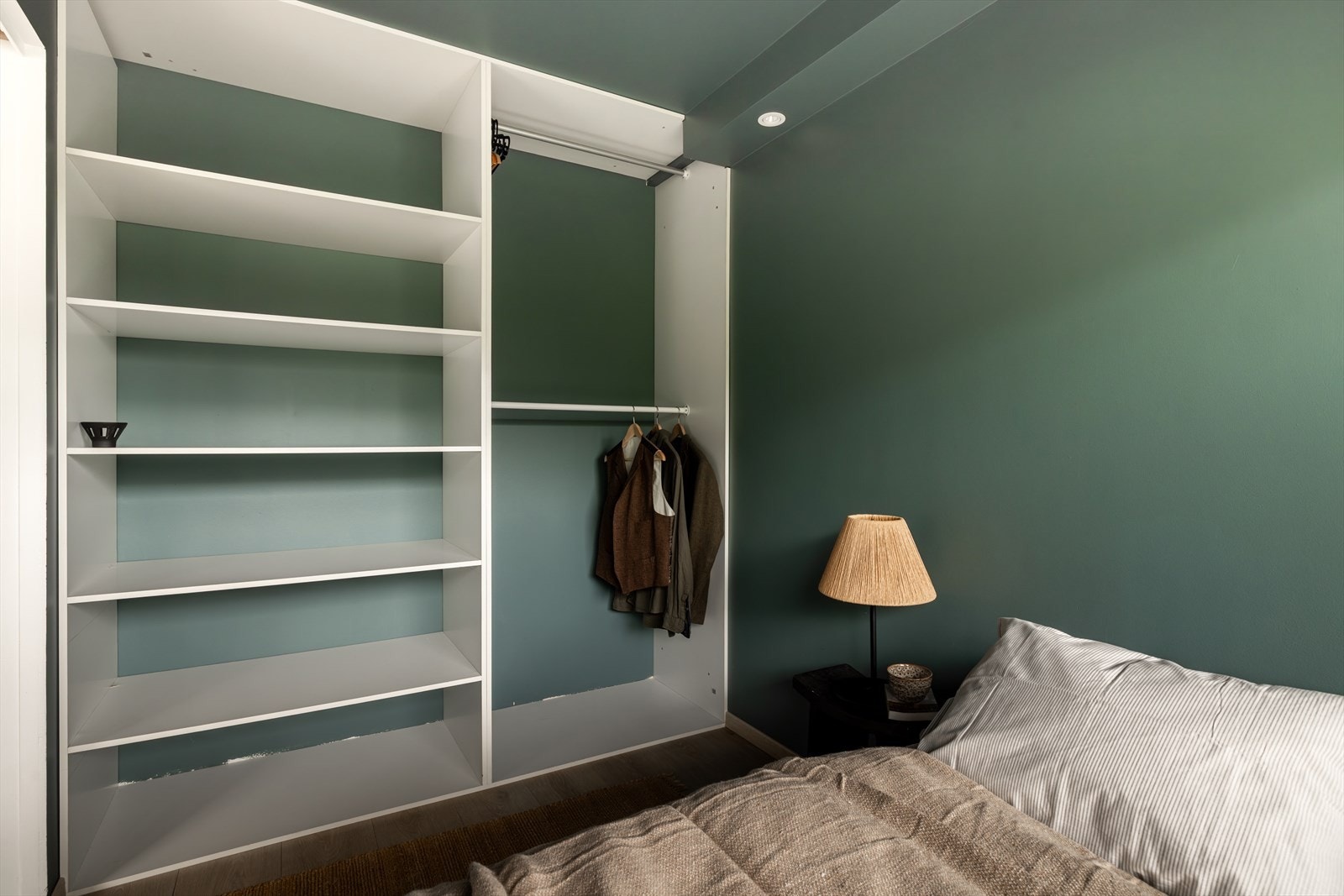 Det er satt opp garderobeløsning med både hylleplass og heng - en praktisk og plassbesparende løsning for oppbevaring. Galleribilde