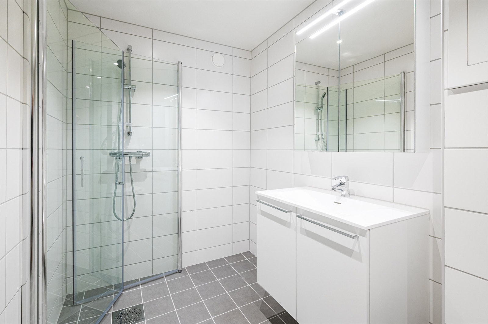 Badet har flislagte overflater, downlights i himlingen og gulvvarme for en lun og god start på dagen. Galleribilde