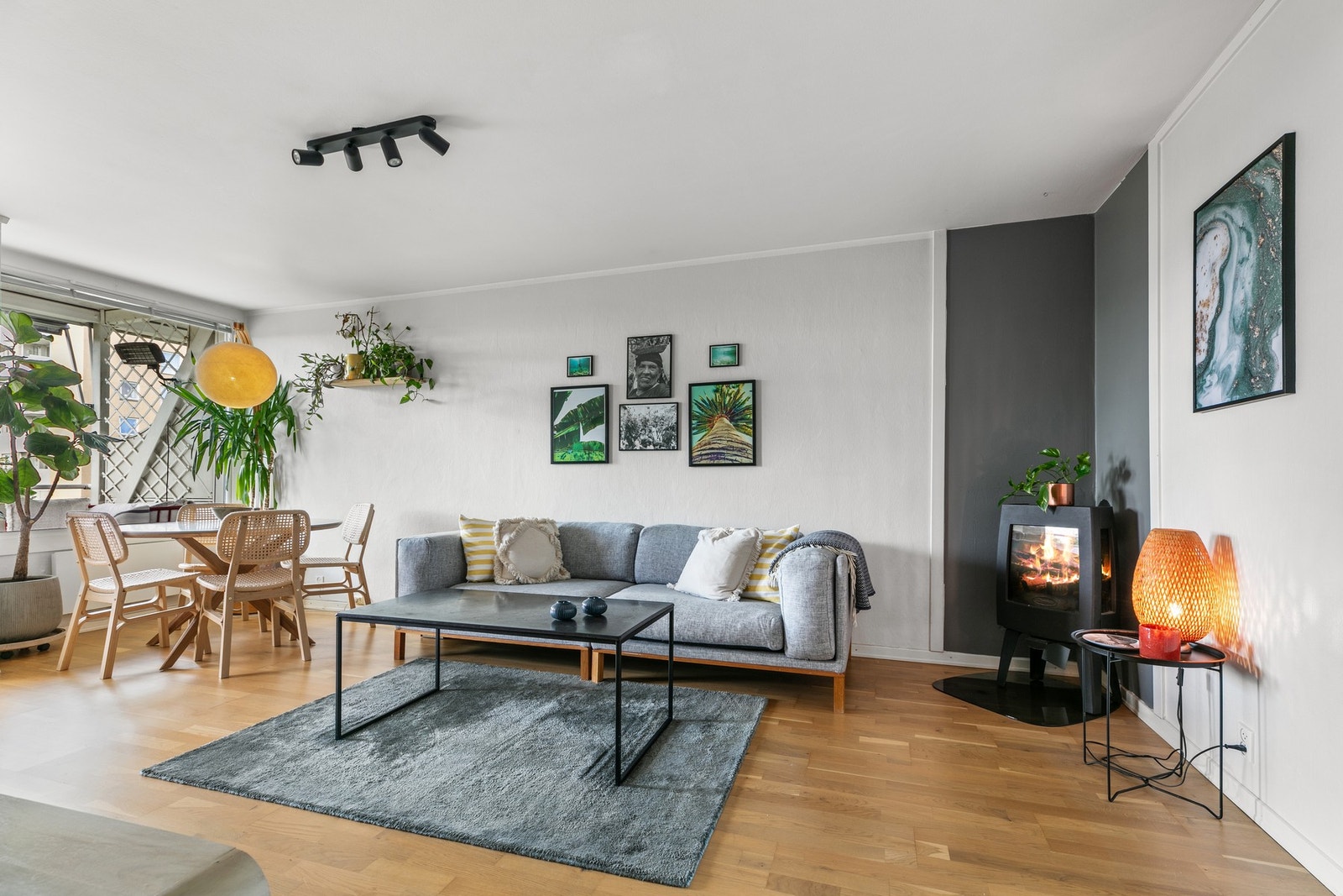 Lys og romslig stue med store vinduer, moderne peisovn og god plass til både sofagruppe og spisebord. Galleribilde