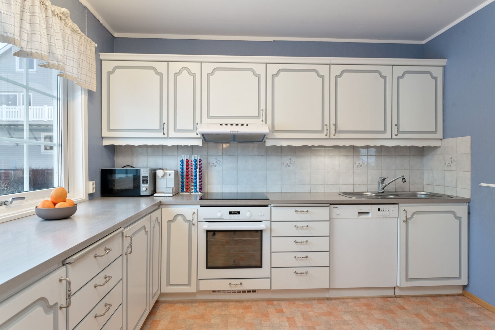 Kjøkkenet har innredning med profilerte fronter og benkeplate av laminat. Galleribilde