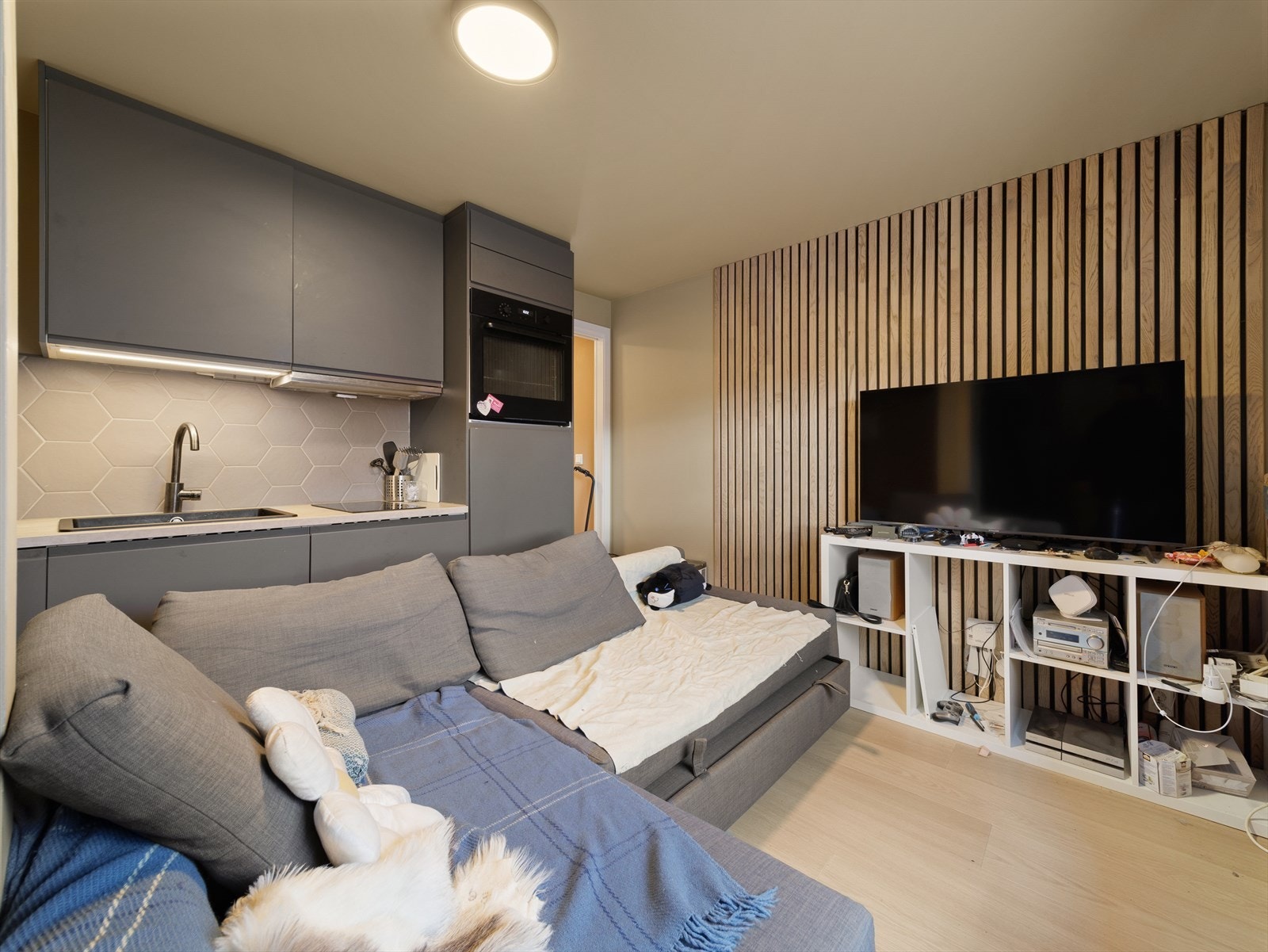 Stuen har en fin spilevegg som gir en lun og dempet romfølelse Galleribilde