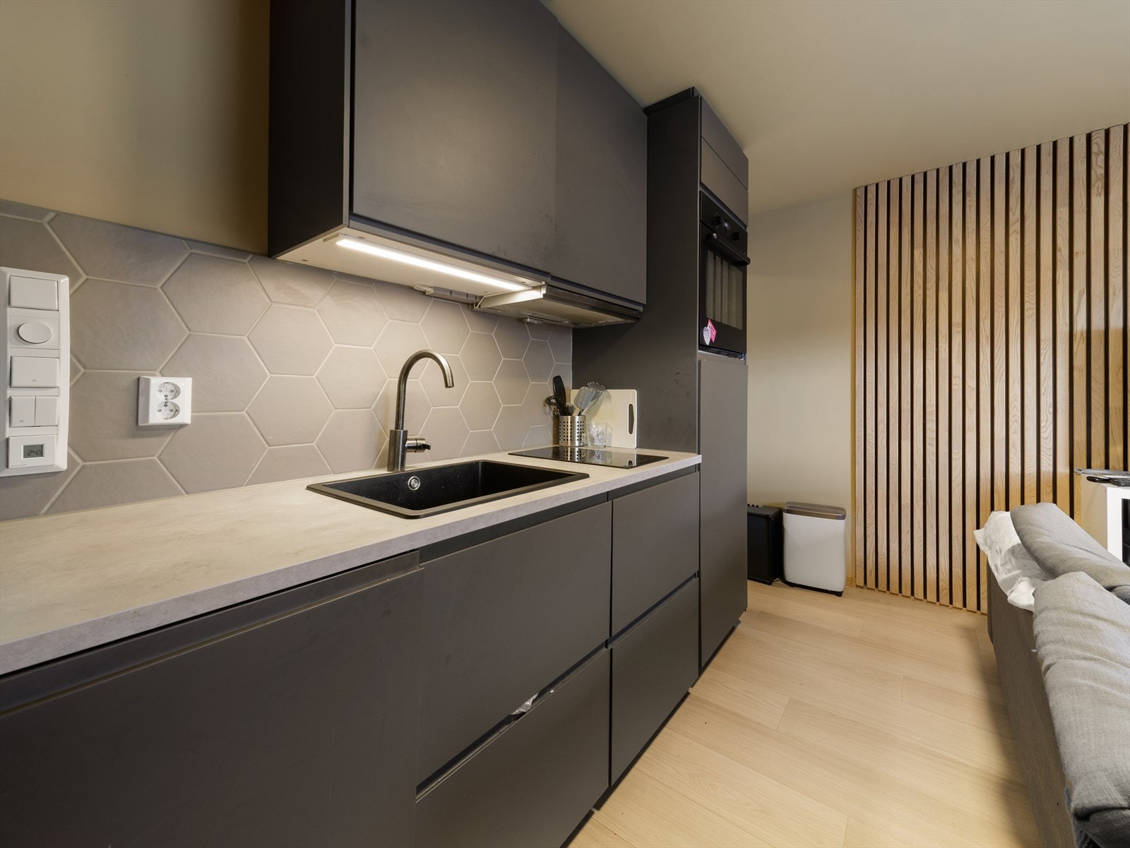 Kjøkkenet er utstyrt med integrerte hvitevarer som ovn, induksjonstopp, oppvaskmaskin og kjøleskap Galleribilde