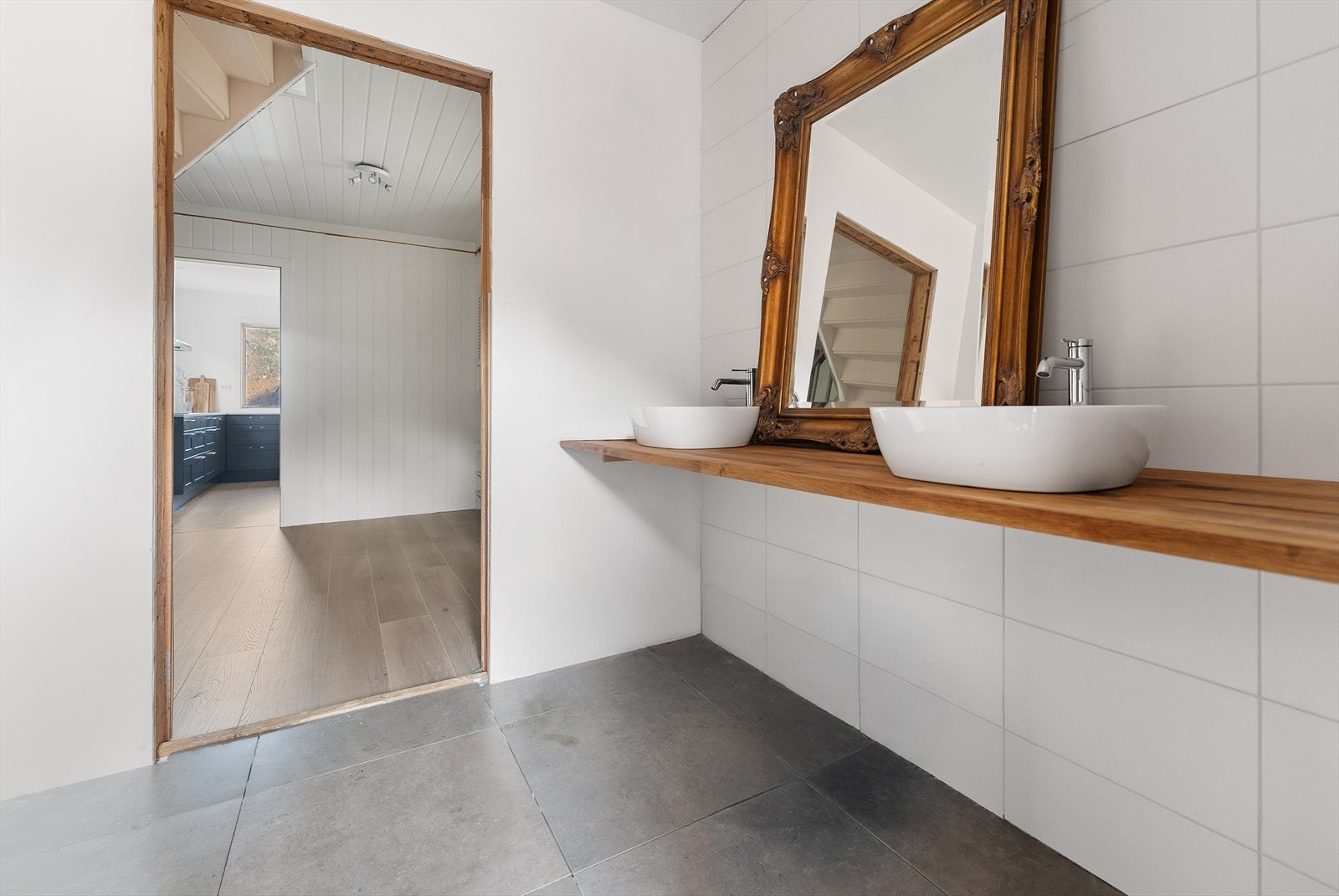 Badet har to dusjnisjer og ramme til vegghengt toalett har komt opp. Benkeplate med to servanter er montert. Galleribilde