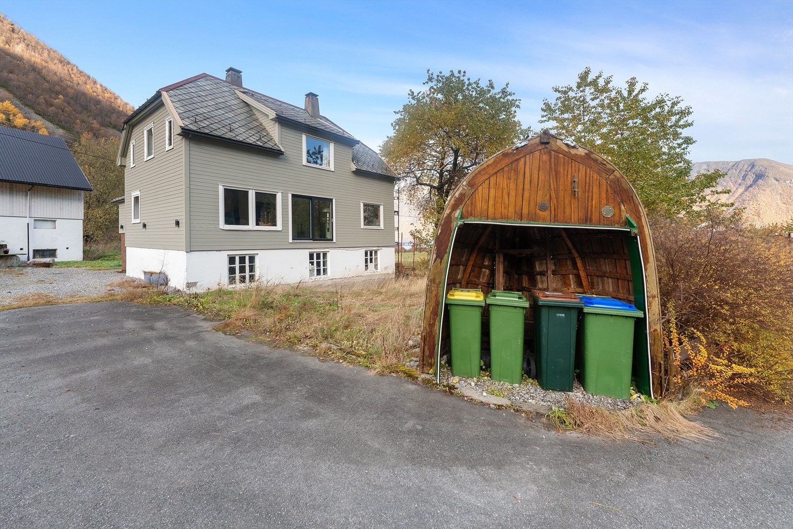 Tomten er opparbeidet med ny asfaltert innkjørsel fra fylkesveien til det gruslagte tunet. Galleribilde