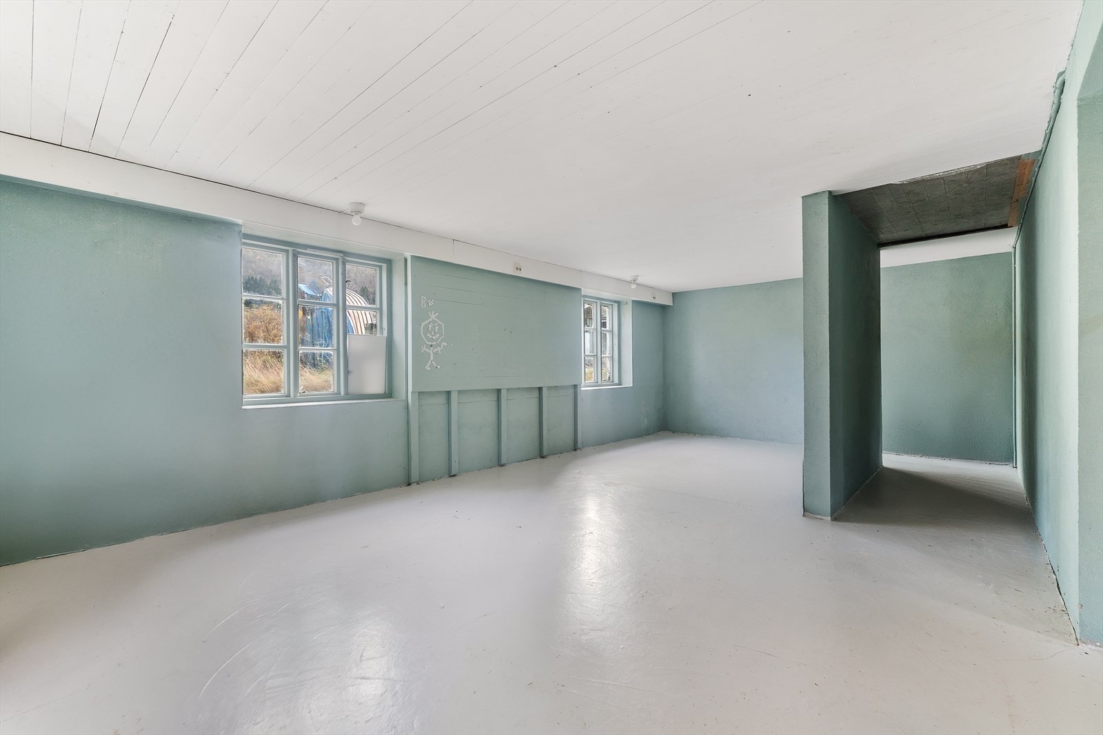 I underetasje er det betonggulv og synlige murvegger ned mot gulv i hele kjelleren Galleribilde