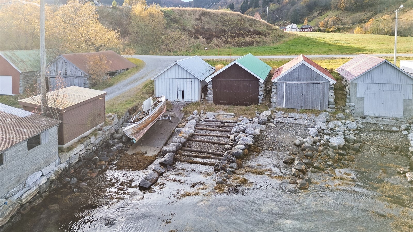 Fundamenter og yttervegger av betong, bordkledd gavel mot vegen og støa, oppsingelet golv i midten, betong ut mot veggene (fundament), saltak av tre tekket med stålplater. Galleribilde