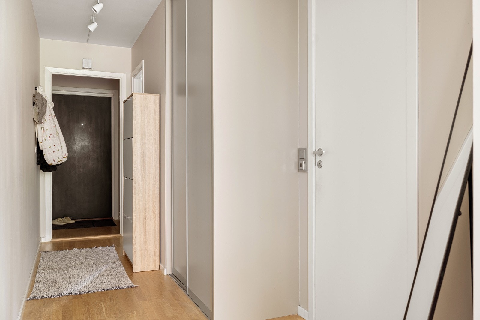 Fra entréen kommer du videre inn i en praktisk gang med god oppbevaringsplass i stor plassbygget skyvedørsgarderobe. Det er også ytterligere plass til oppheng av yttertøy, samt flere sko i medfølgende skoskap. Galleribilde