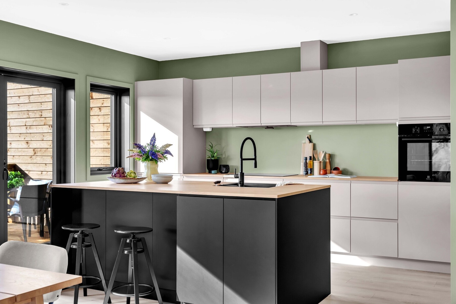 Stilig sort og beige Kvik kjøkkeninnredning med god skap- og benkeplass. Galleribilde