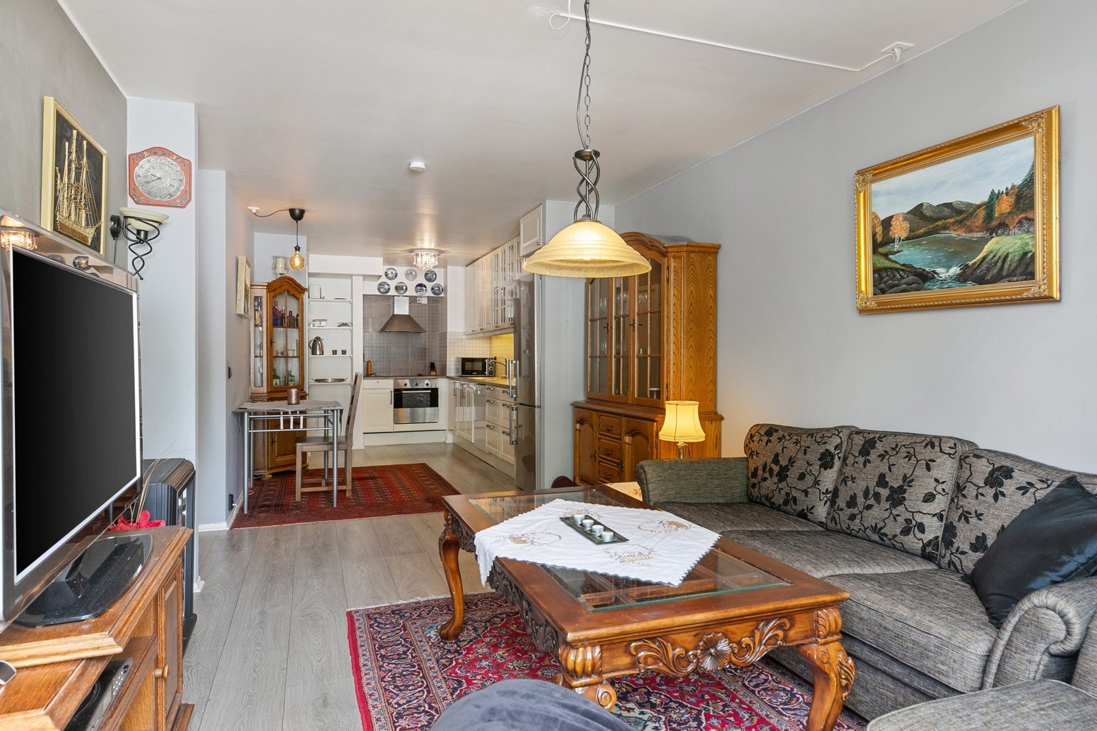 Lys stue, med slette vegger og himling, og tidsriktig en-stavs laminat på gulvet Galleribilde