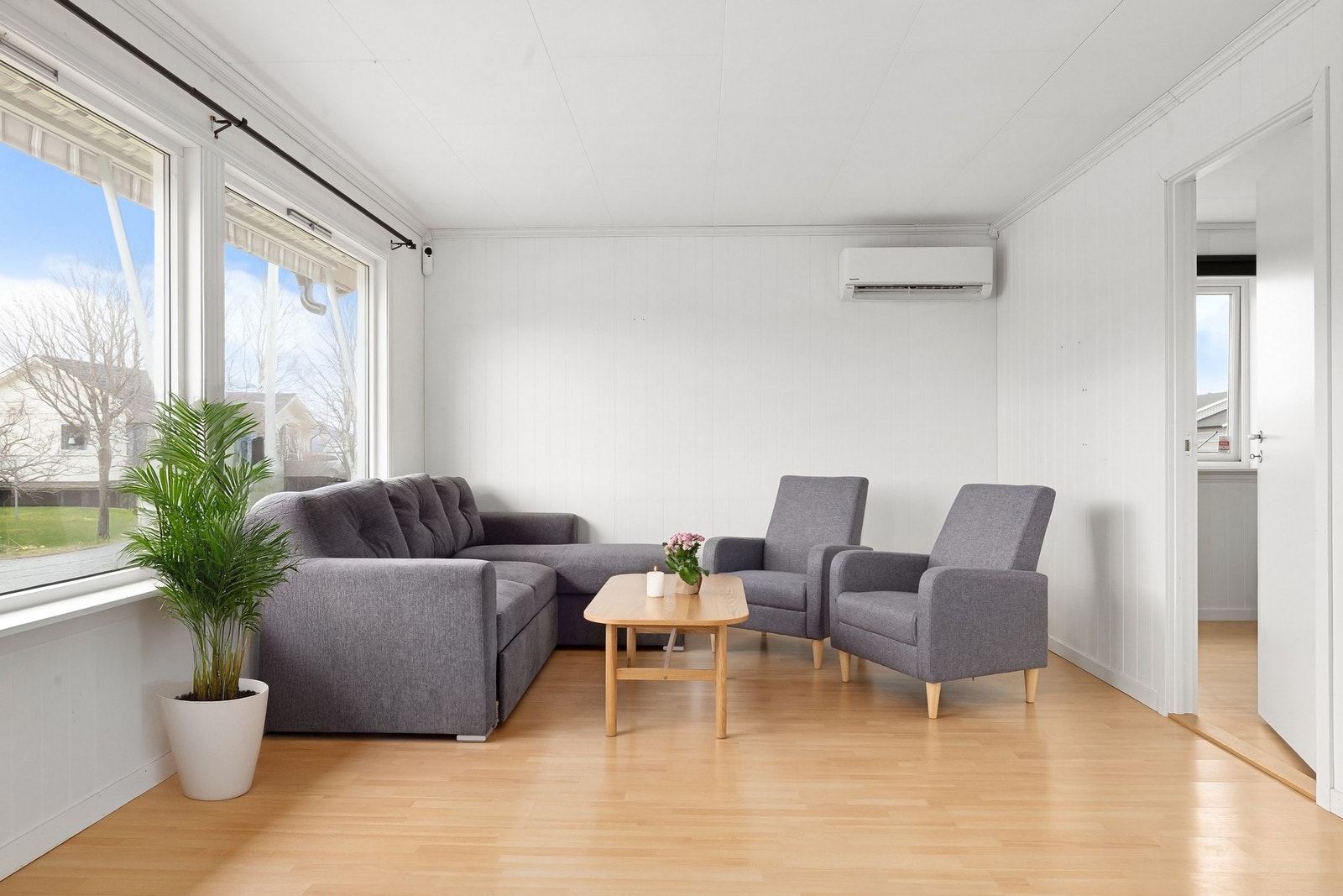 Stuen byr på store vinduer som lyser opp boligen Galleribilde