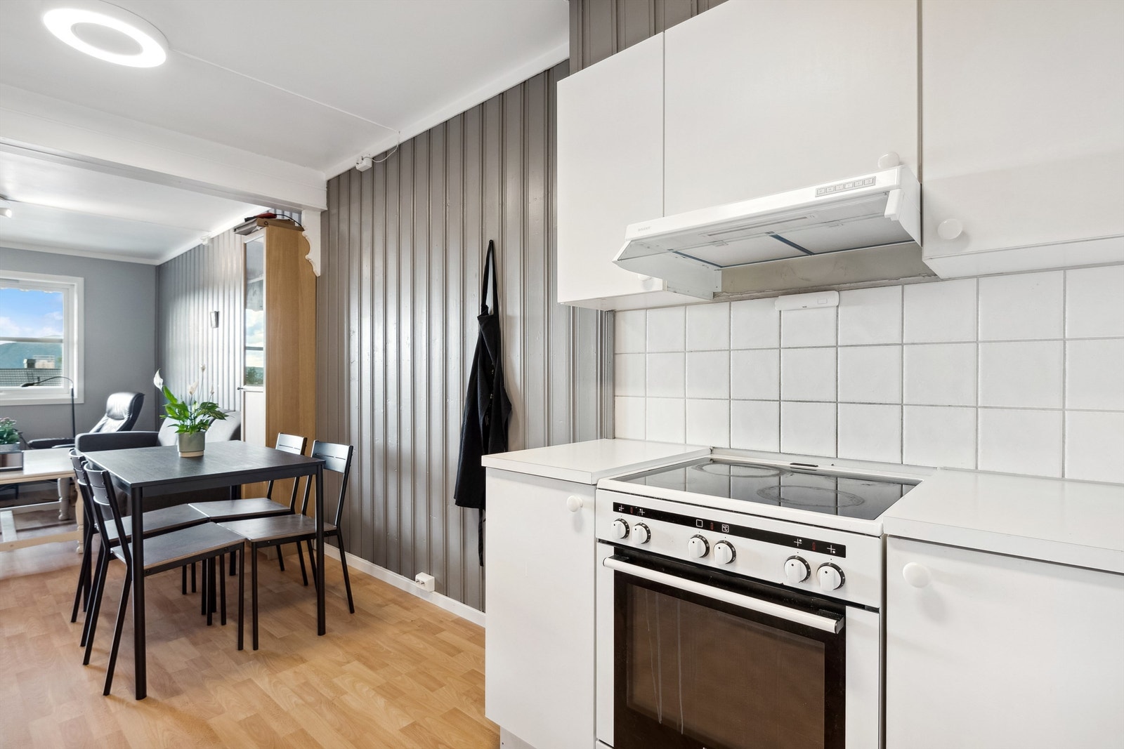 Kjøkken og stue i åpen løsning med en fin spiseplass i mellom. Galleribilde