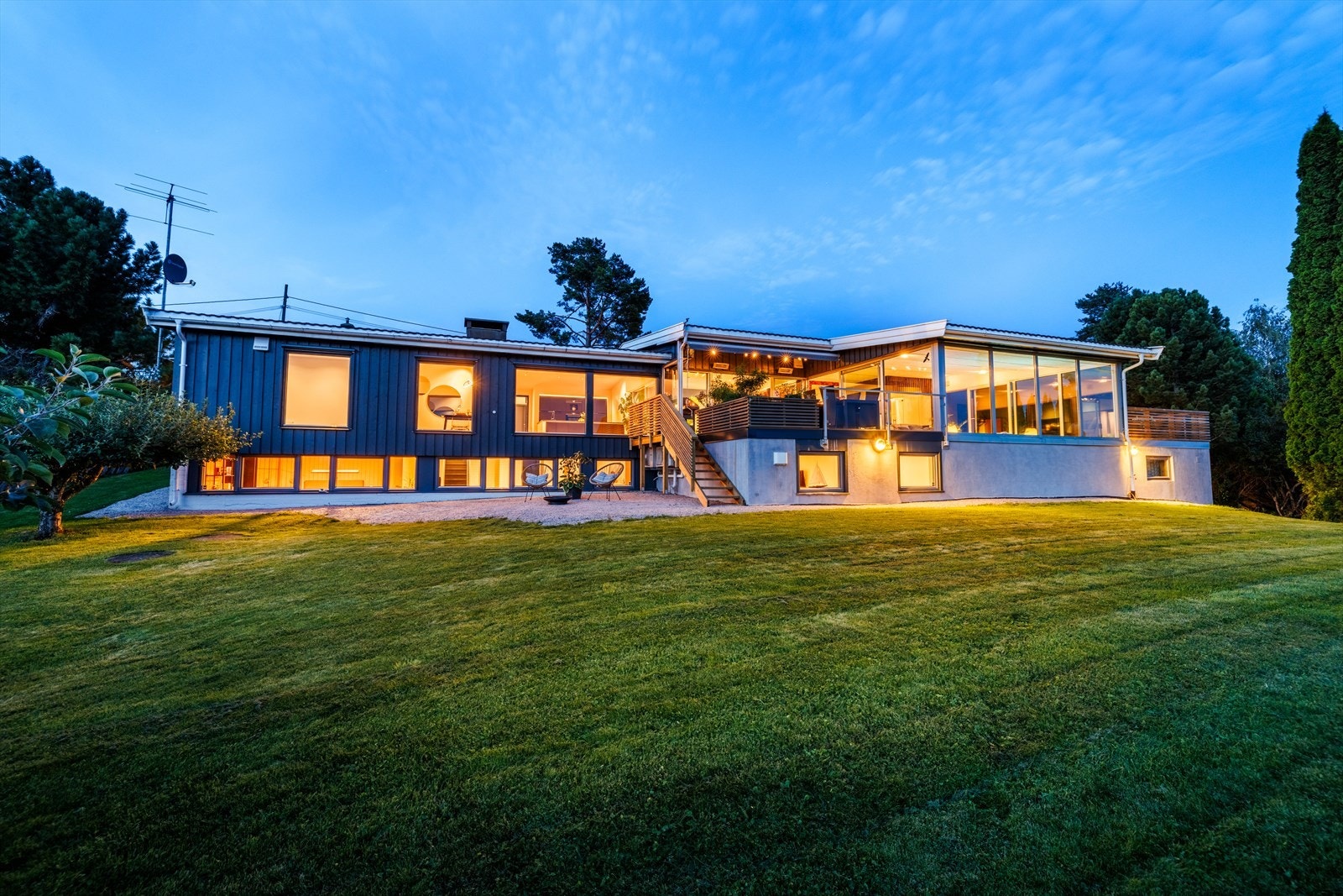 Eiendommen ligger tilbaketrukket med usjenert tomt og stort plenareal. Galleribilde