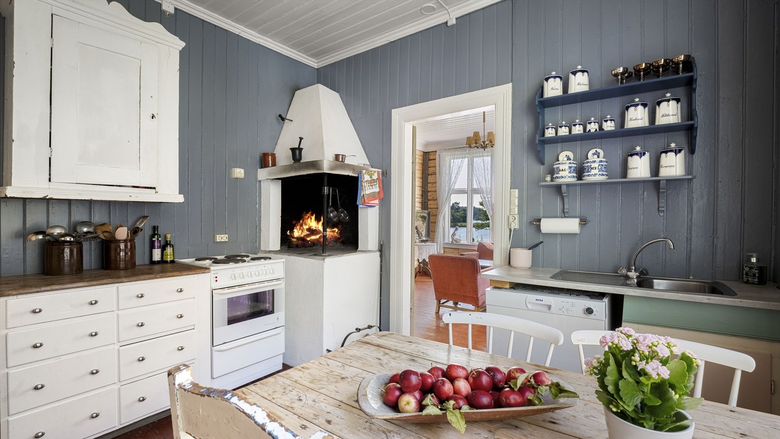 Romslig kjøkken med hyggelig, åpen peis - et av 6 ildsteder i boligen Galleribilde