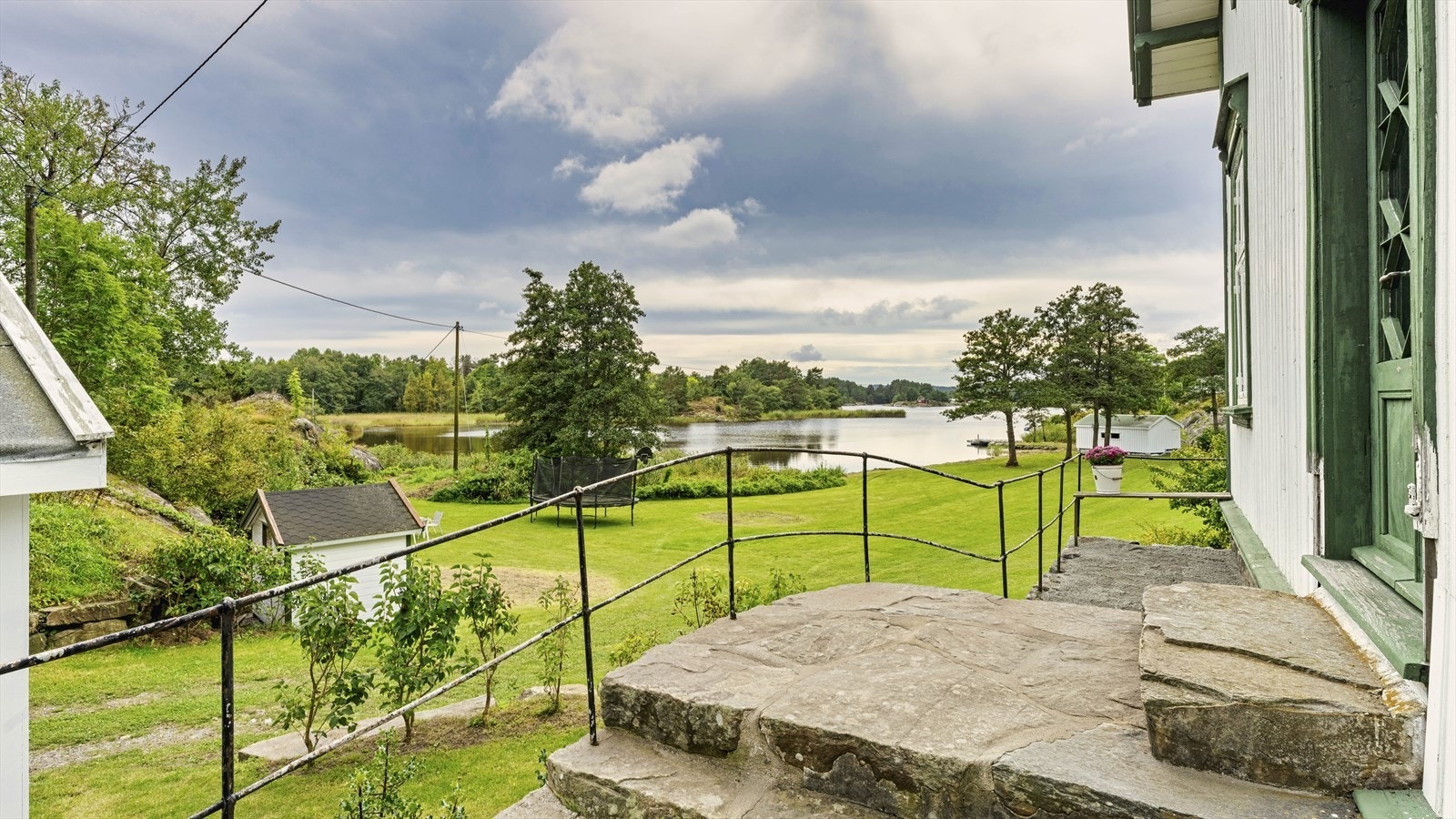Uteområde har flotte naturstein og fint smijernsgjerde ved inngangspartiet Galleribilde