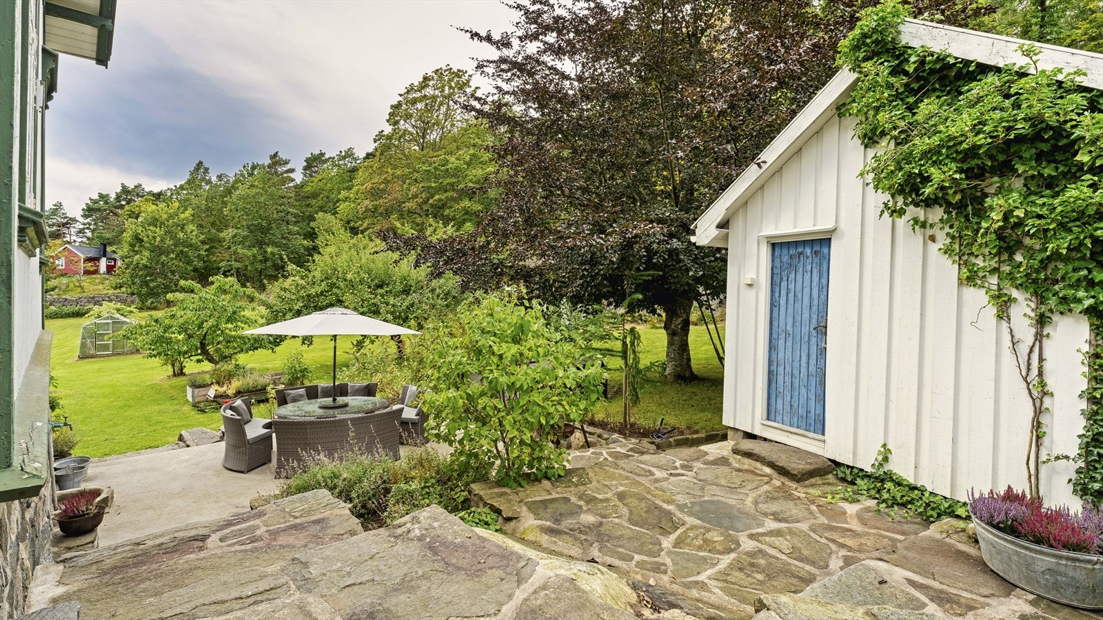 Uteområdet på siden av huset er fint opparbeidet med naturstein og støpt dekke Galleribilde
