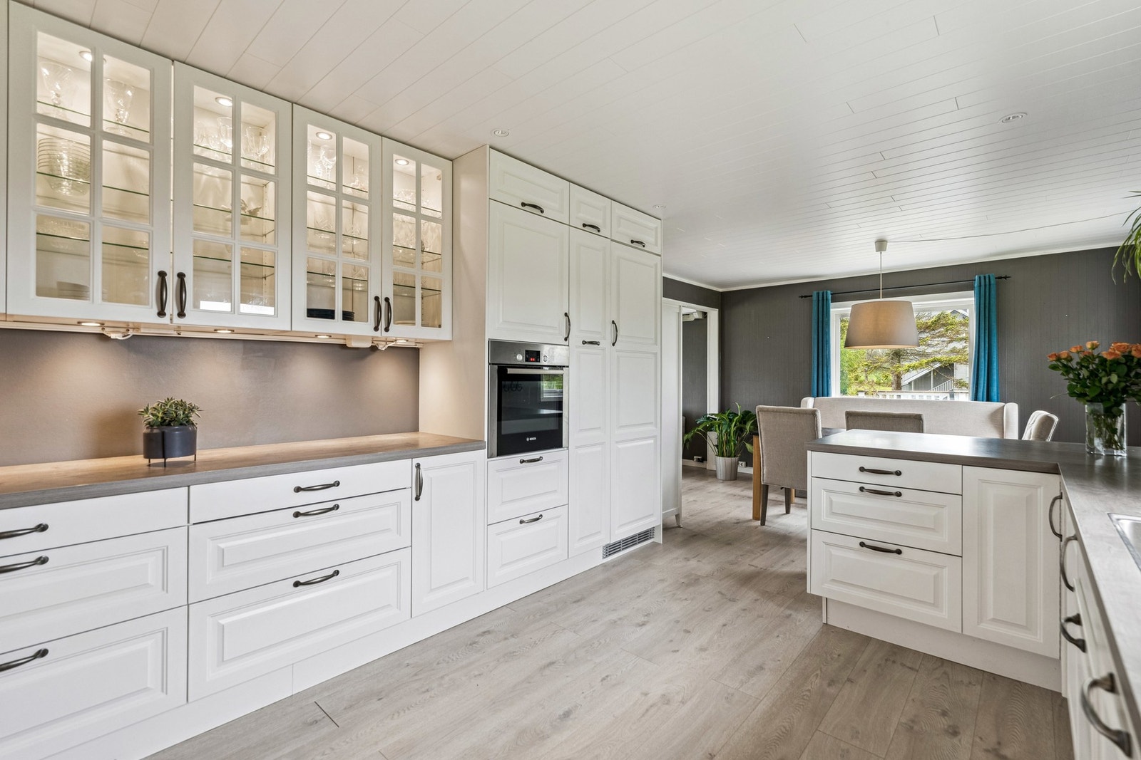 Kjøkkenet har innredning med profilerte fronter, laminat benkeplate og flis mellom kjøkkenbenk og overskap Galleribilde