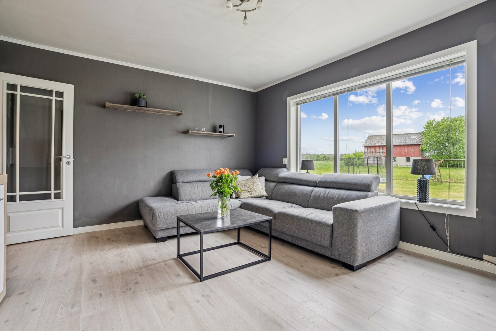 Stue med glatte overflater og laminatgulv Galleribilde