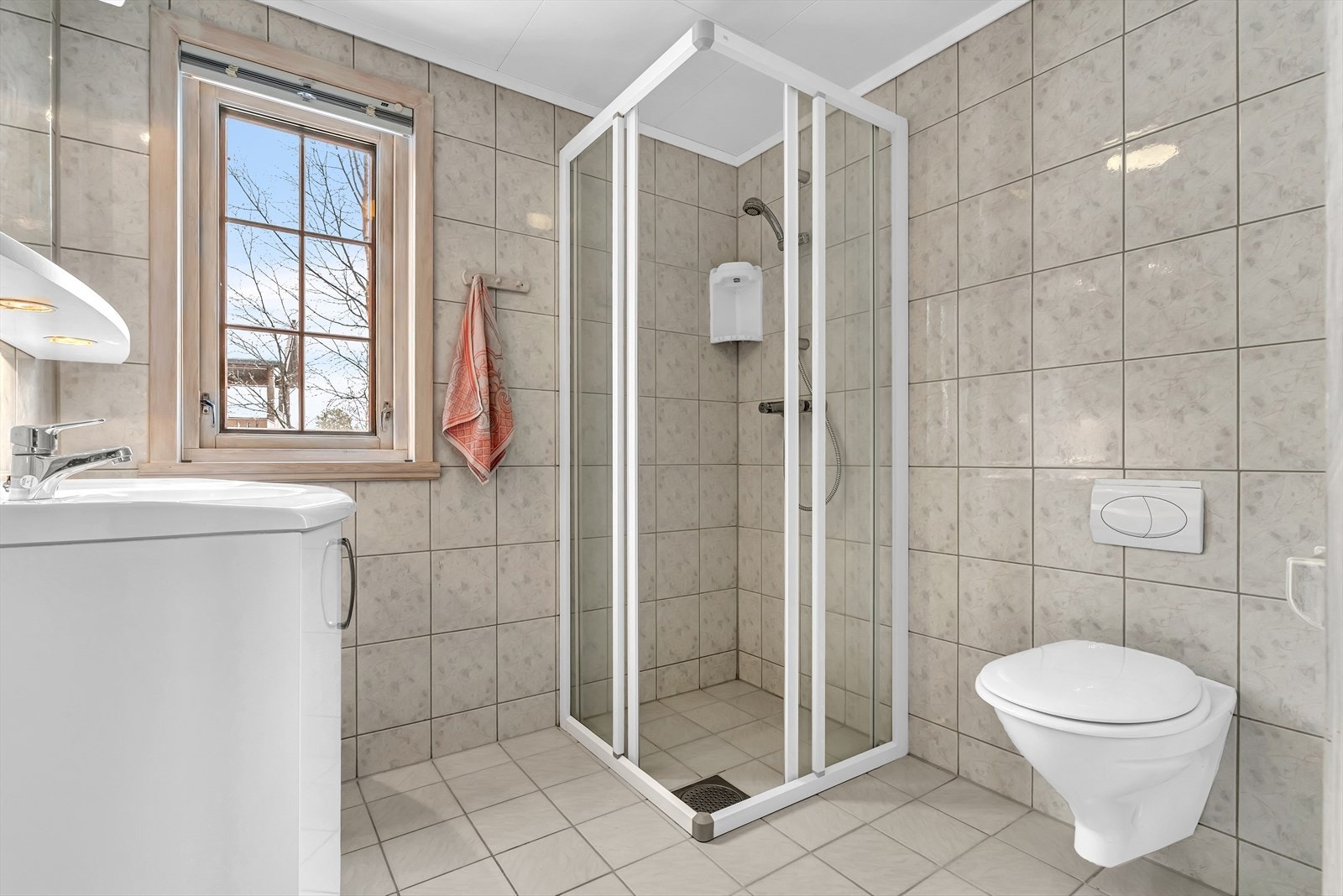 Moderne helfliset baderom med vegghengt toalett, og dusjhjørne. Galleribilde