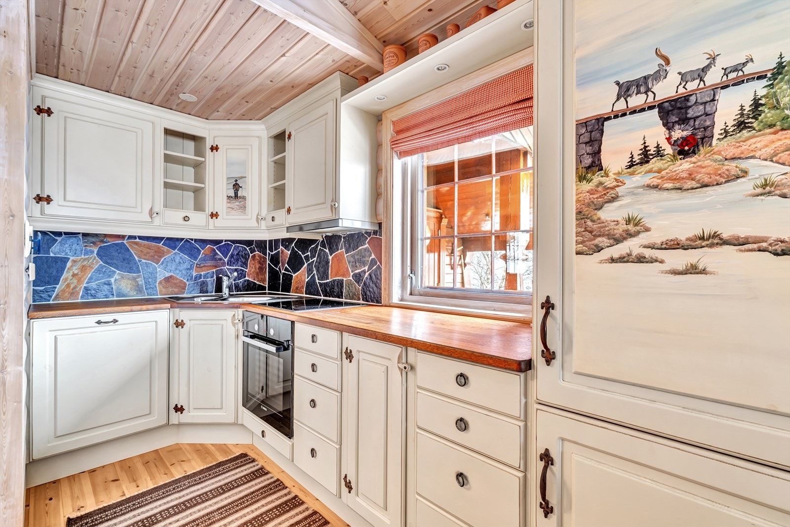 Koselig hyttekjøkken med malerier fra eventyr. Galleribilde