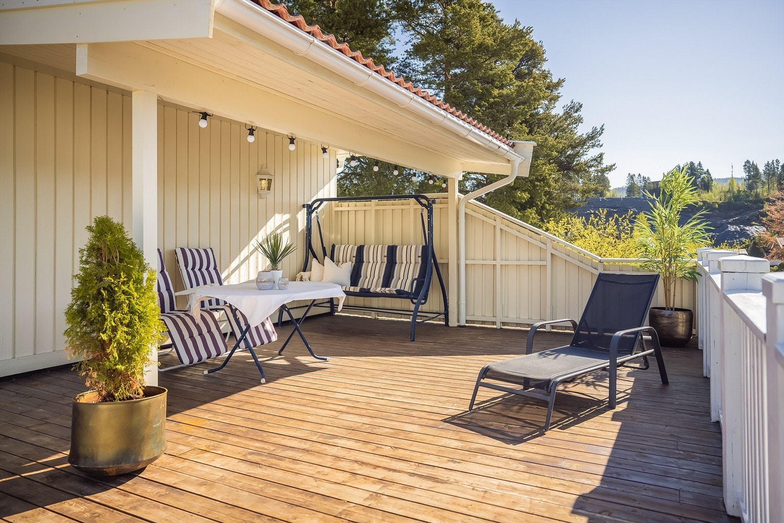 Terrassen over garasjen ligger sydvendt og har et praktisk takoverbygg Galleribilde