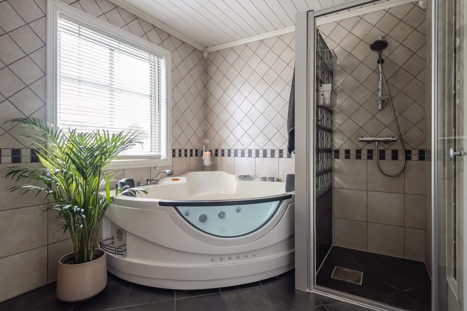 Stor dusjsone og medfølgende boblebad. Rommet har et eksklusivt preg med flotte detaljer i rommet. Solid glassbyggerstein i dusjsonen Galleribilde