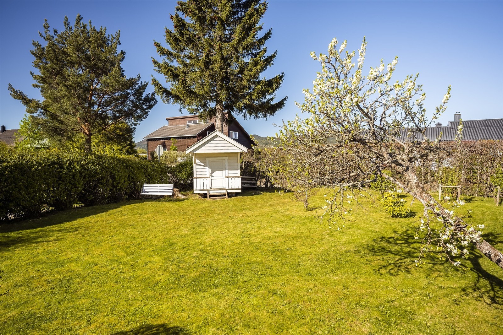 Frittstående dukkestue plassert på hjørnet av plenen Galleribilde