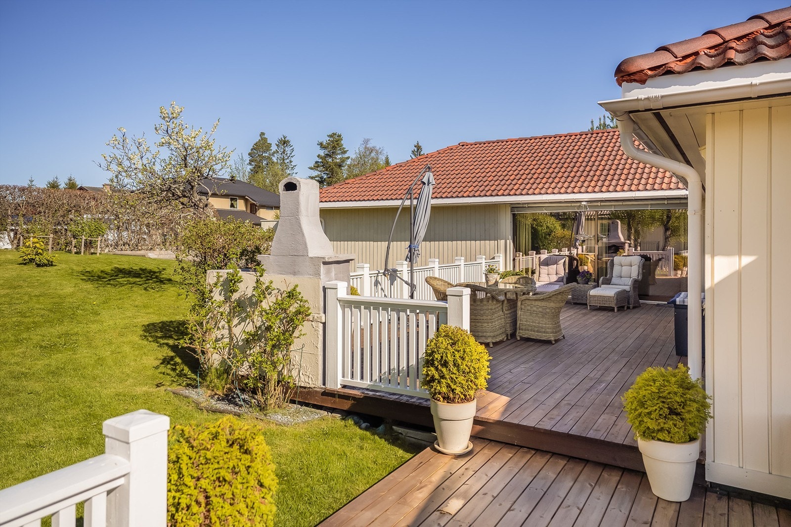 Terrasser og plen er satt sammen slik at de går plant med hverandre og gir enkel tilgang til hele tomten Galleribilde