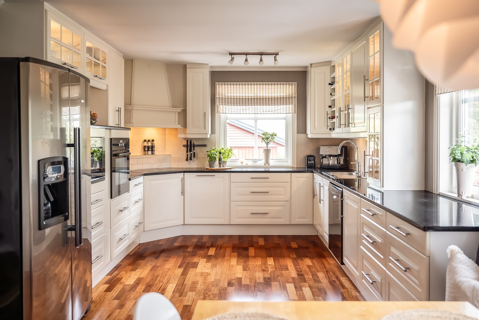 Stor og pen kjøkkeninnredning med rikelig med skap- og benkeplass Galleribilde