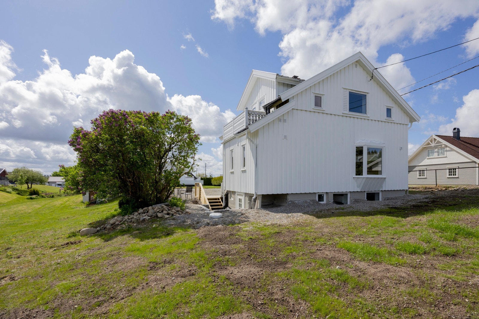 Flat, solrik tomt med beplantning og plen. Galleribilde