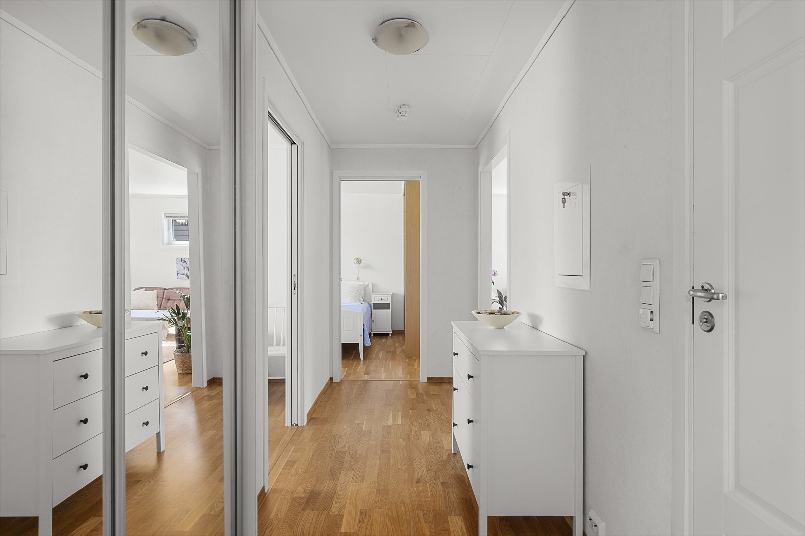 Velkommen inn til en lys og fin gang med skyvedørsgarderobe Galleribilde