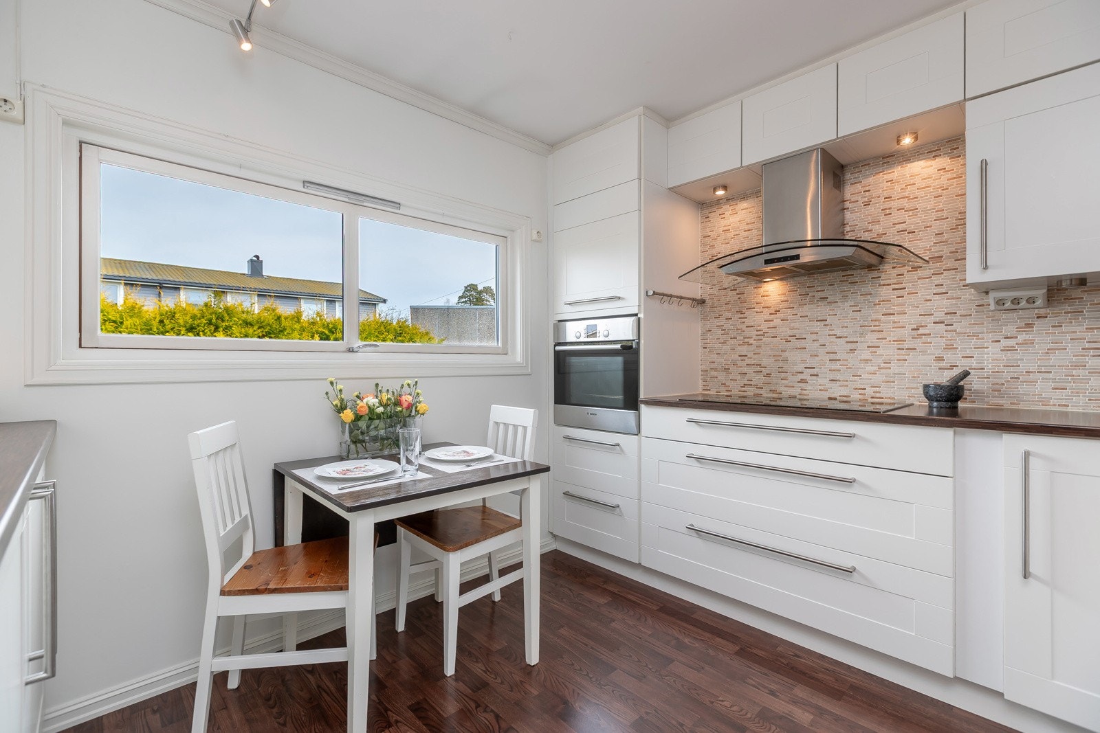 Kjøkken i lyse fronter og fliser over benk Galleribilde