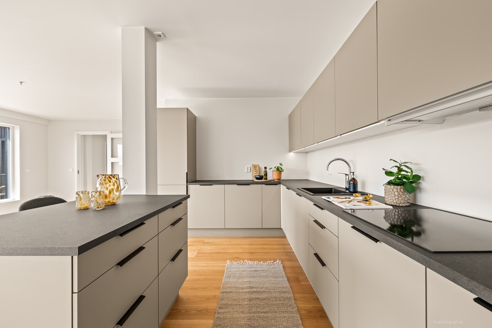 Kjøkkenet er utstyrt med kjøl/fryseskap, oppvaskmaskin, stekeovn i høy skap, induksjonstopp, vannstoppstystem og komfyrvakt. Det er flexit ventilator over platetopp. Galleribilde