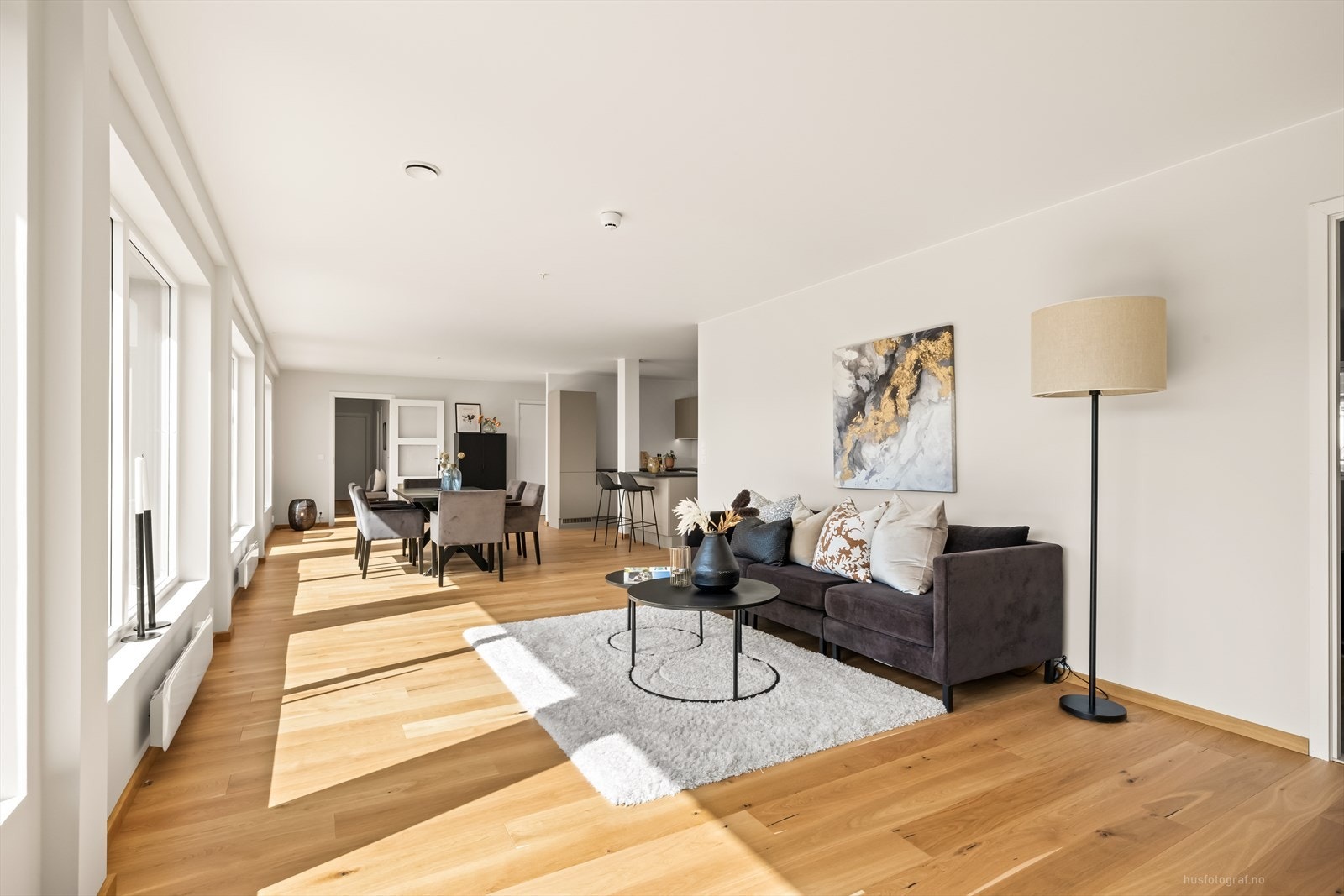 Lys og innbydende stue med parkett på gulv og slette vegger malt i duse farger som skaper en lun og koselig stemning. Galleribilde