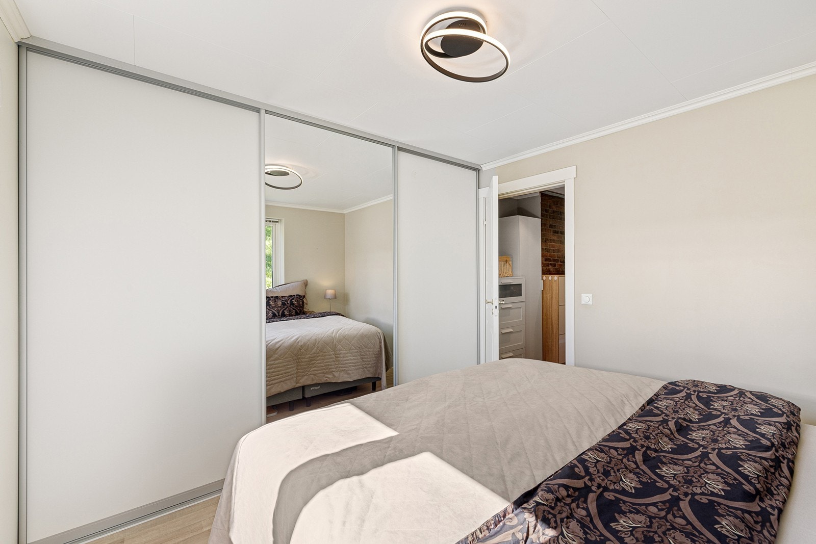 Soverom 1 - Rommet har plass til dobbeltseng, og en praktisk skyvedørsgarderobe som holder rommet ryddig og rolig. Galleribilde
