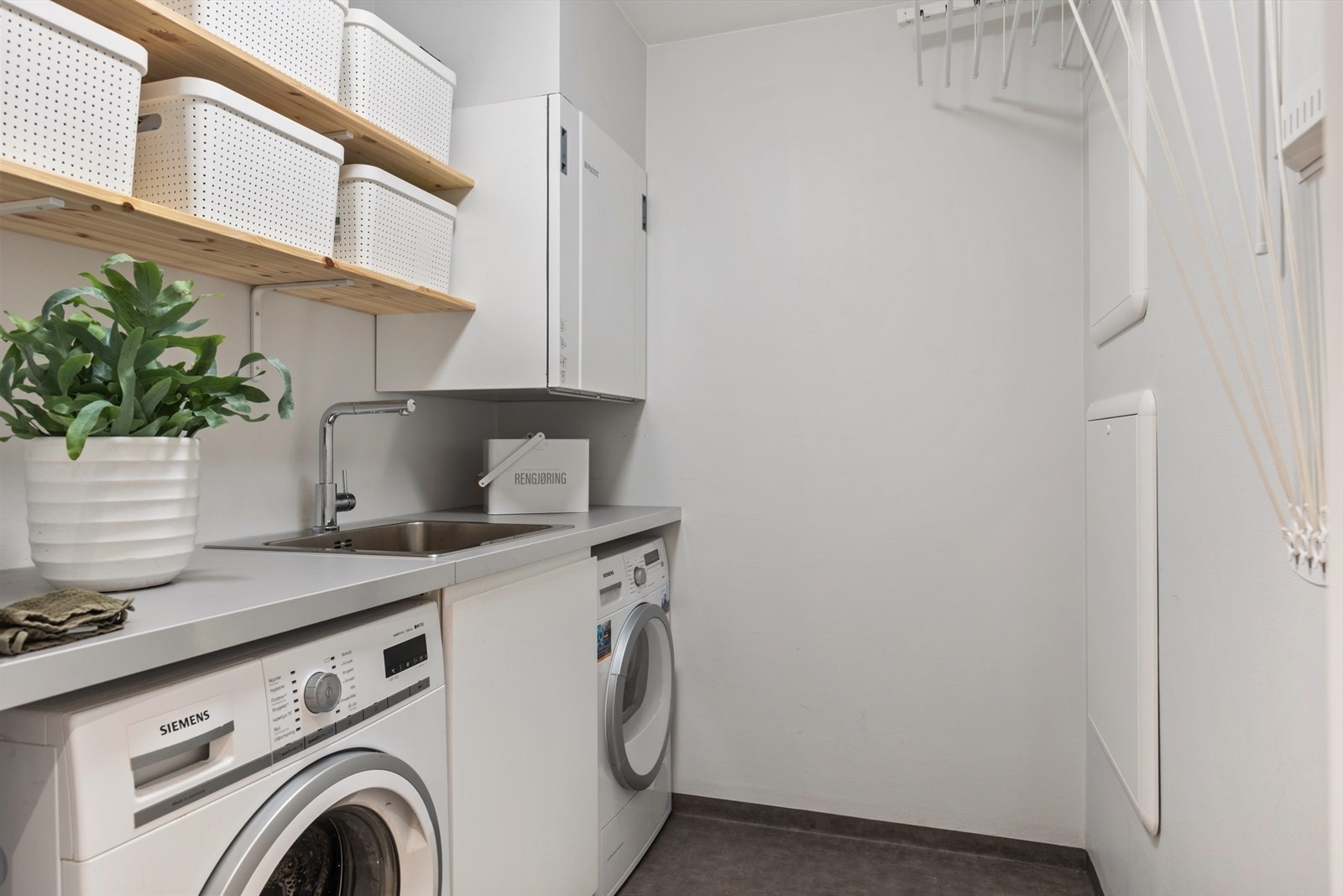 Vaskerom har plass for både vaskemaskin, tørketrommel og lagring. Takmontert tørkestativ som heises opp. Galleribilde