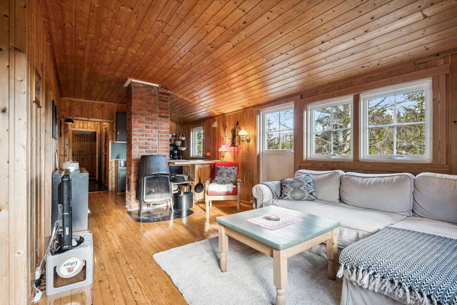 Stue med vedovn og åpen løsning til kjøkkenet, sånn at samtalene med gjestene kan fortsette når du lager de kosligeste middagene. Galleribilde