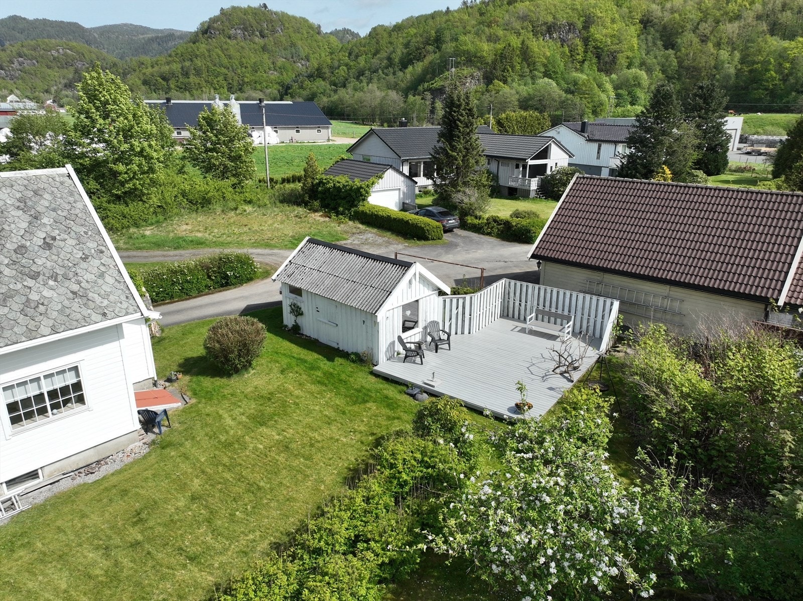 Koselig uteplass med lettstelt plen, terrasse med levegg og redskapsbod. Galleribilde