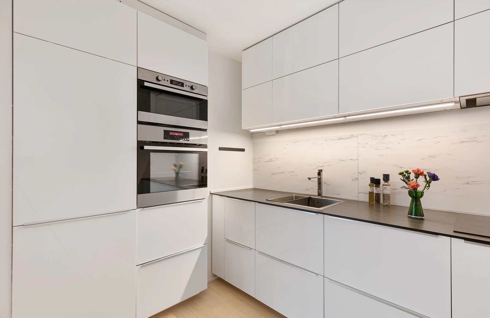 Over benken er det belysning og hvite plater med marmormønster. Galleribilde