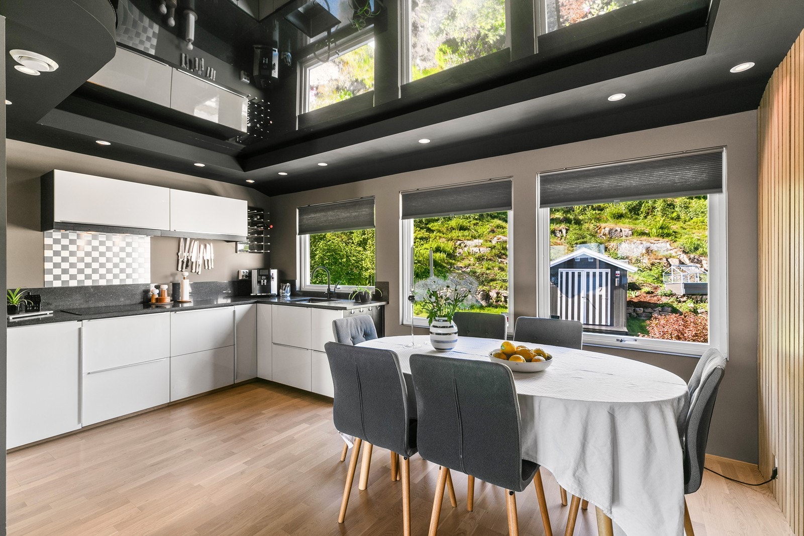 Kjøkkenet har innredning med hvite høyglansfronter med mørk omramming Benkeplate av granitt, med underlimt oppvaskkum. Galleribilde