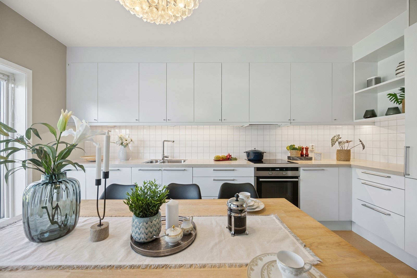 Moderne kjøkken med hvite, glatte fronter og slitesterk laminat benkeplate. Galleribilde