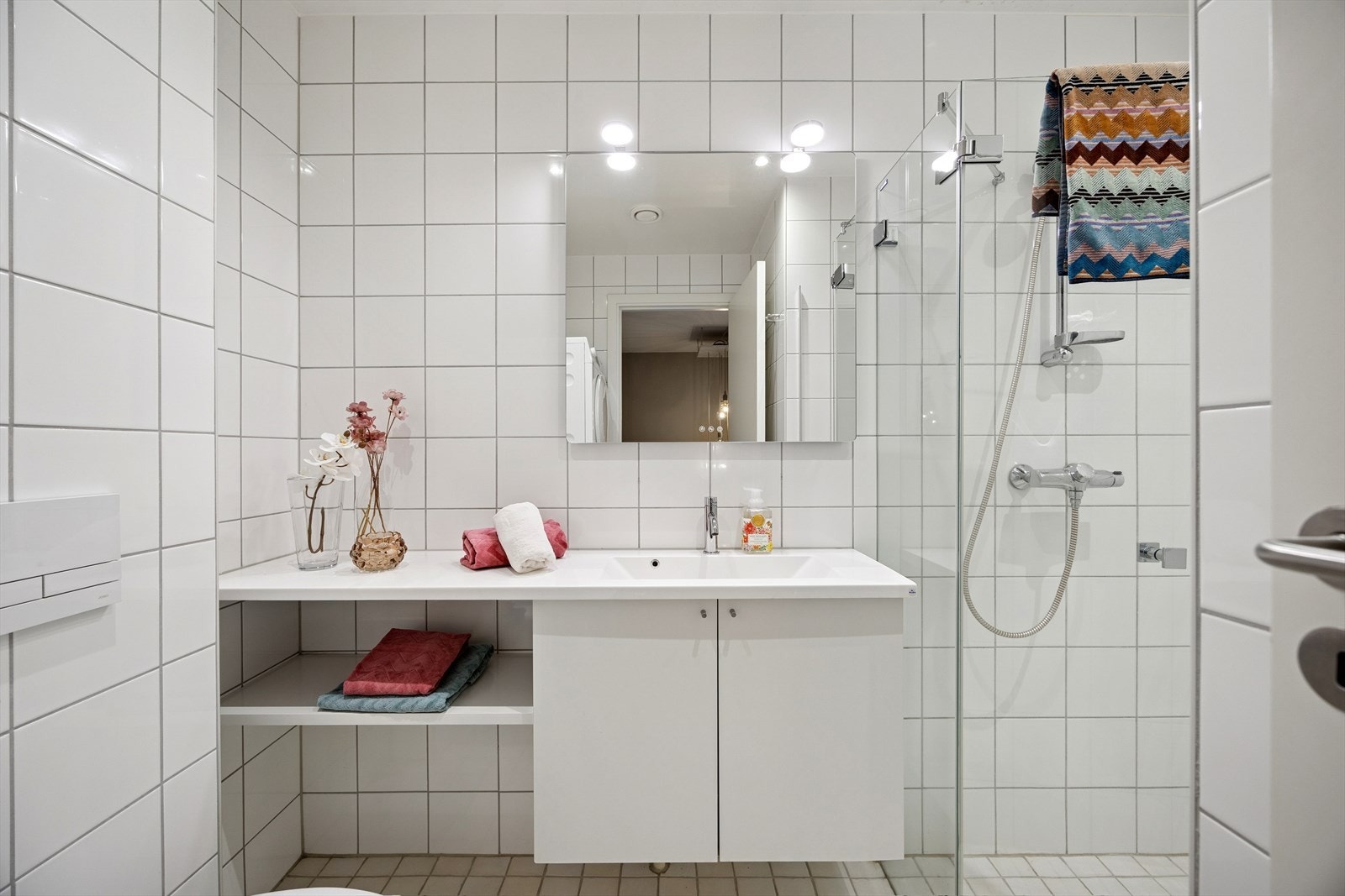 Baderommet ved trappen er romslig og delikat, med fliser, gulvvarme og moderne innredning - her er det også opplegg for vaskemaskin og tørketrommel Galleribilde