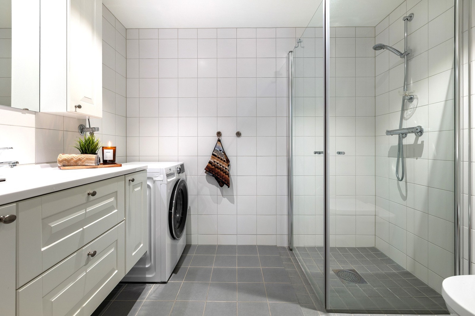 Flislagt baderom med plass til vaskemaskin Galleribilde