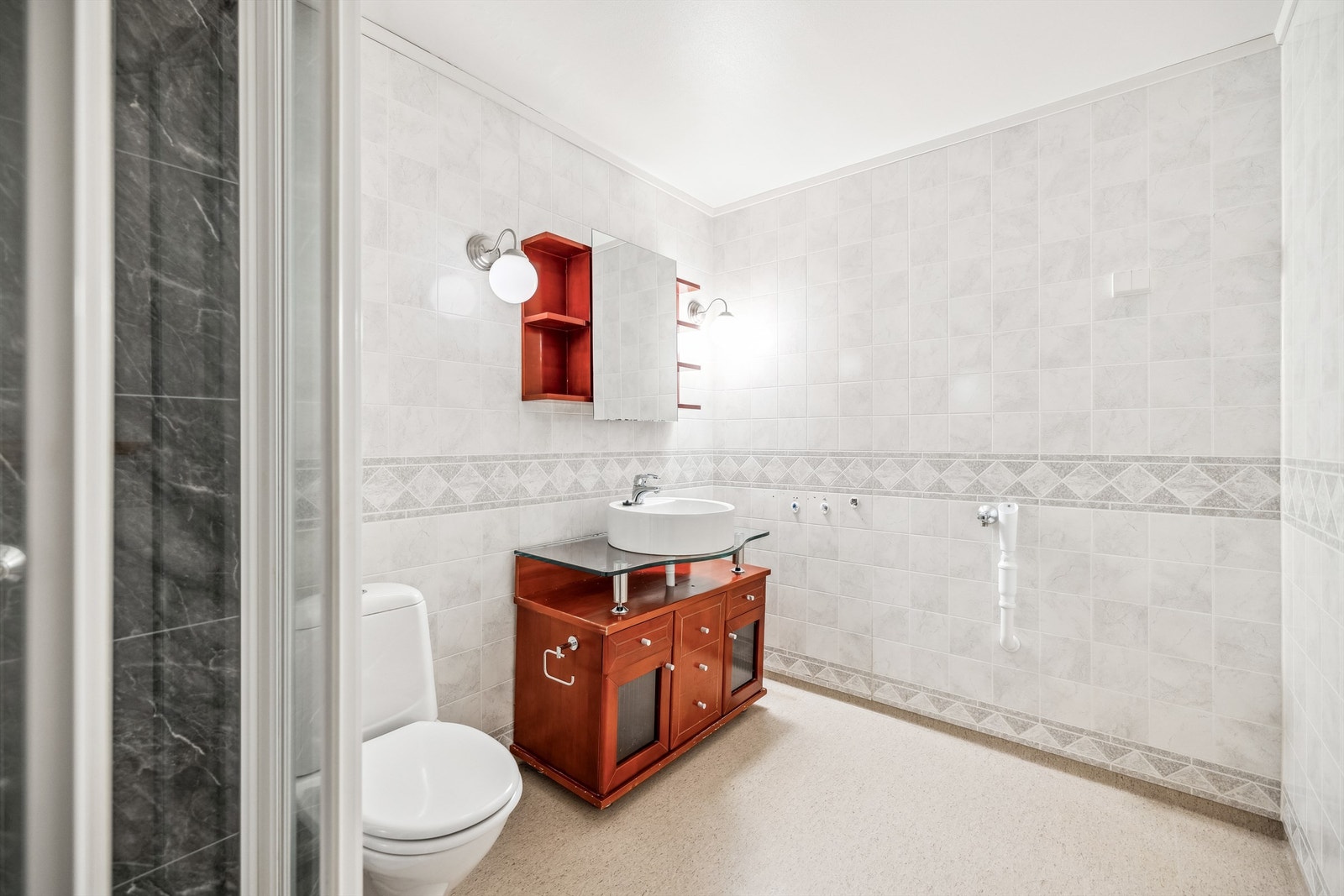 Badet er romslig og inneholder dusjkabinett, gulvmontert toalett og innredning. Opplegg for vaskemaskin Galleribilde