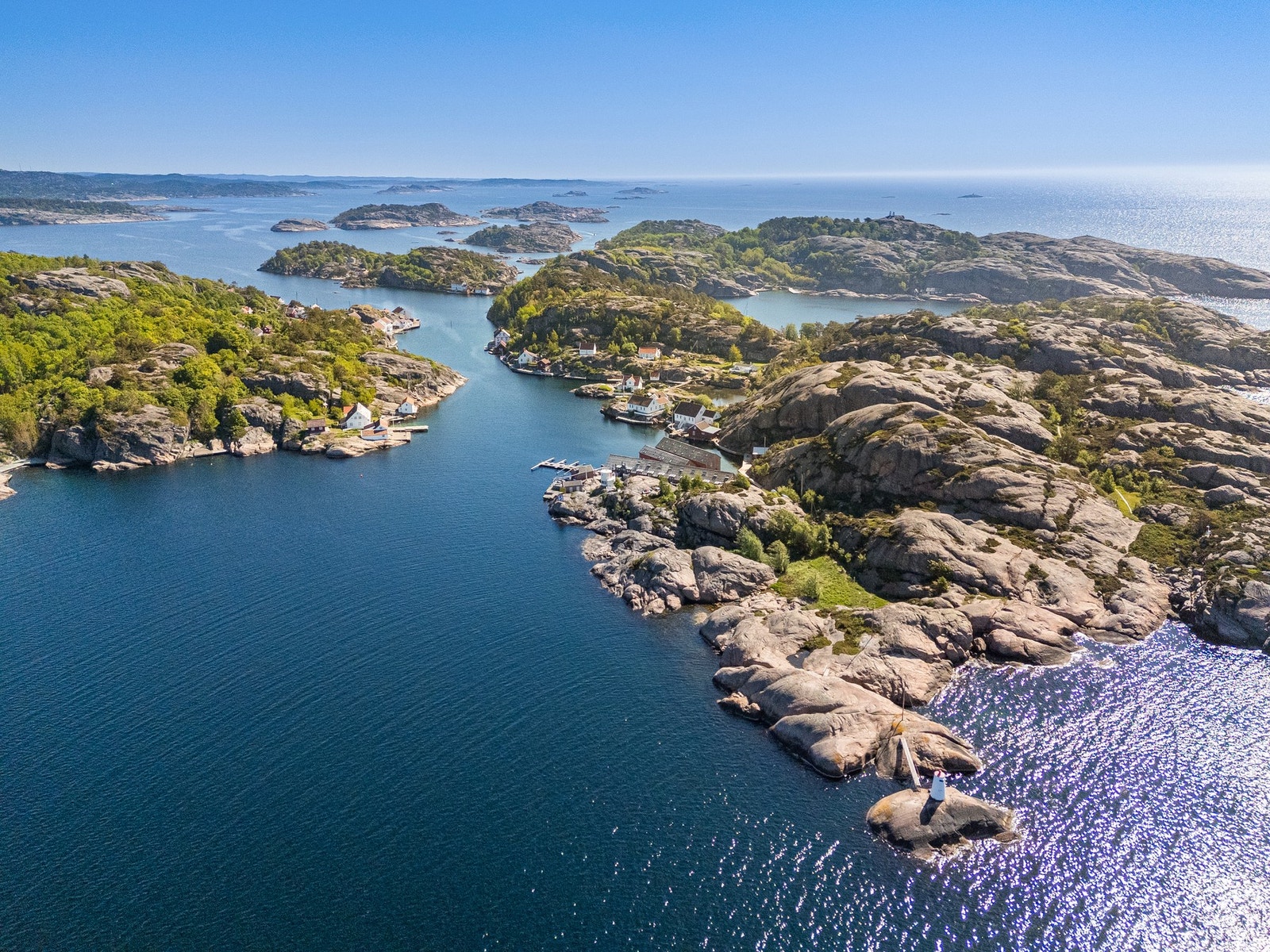 Dronebilde som viser stor del av Ny-Hellesund og havet øverst i bildet Galleribilde