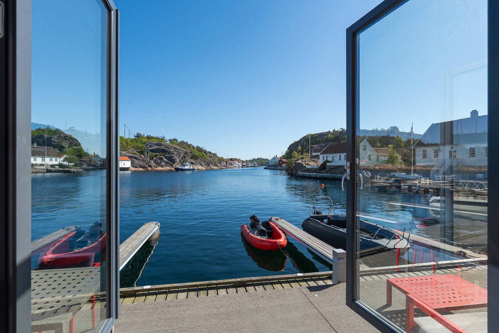 Bilde tatt fra stuen i 1.etg med dobbeldør ut til bryggen og med flott sjøutsikt Galleribilde
